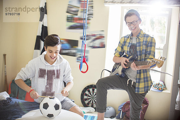 Zwei Teenager  die im Zimmer Musik machen.