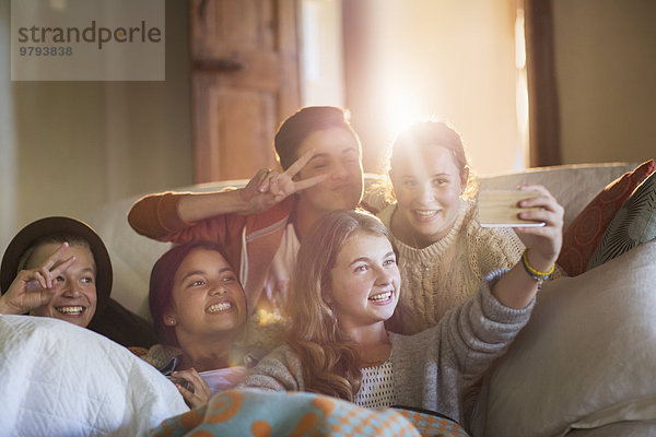 Gruppe lächelnder Teenager auf dem Sofa im Wohnzimmer