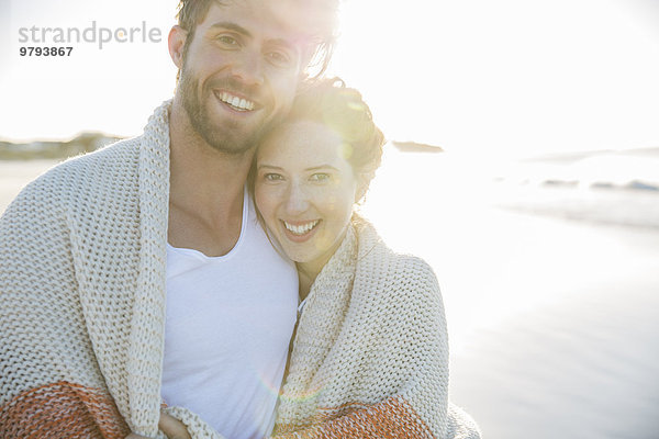 Portrait eines jungen Paares am Strand stehend