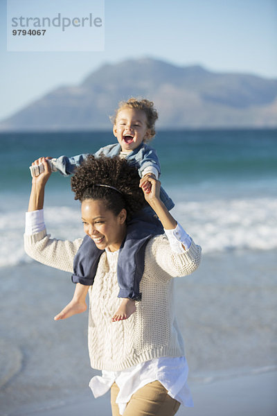 Mutter und Tochter spielen am Strand