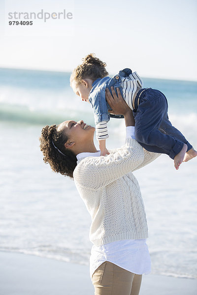 Mutter und Tochter spielen am Strand