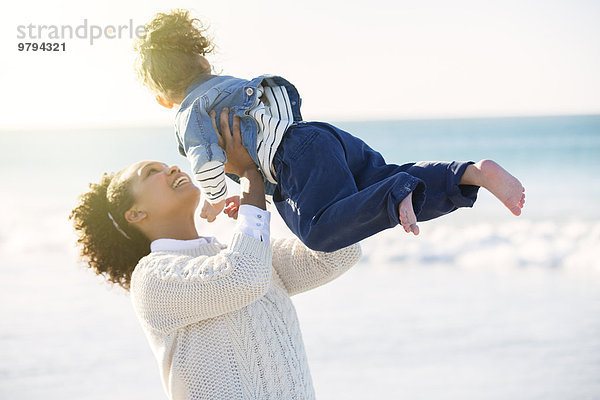 Mutter und Tochter spielen am Strand