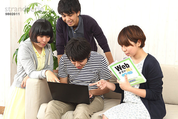 Mensch Notebook Couch Menschen arbeiten jung japanisch