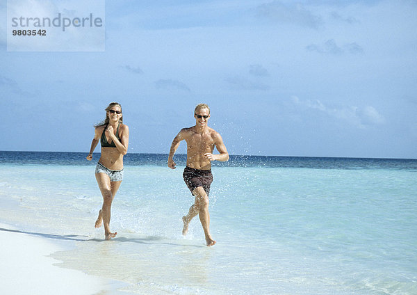 Junges Paar beim Joggen am Strand