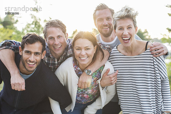 Gruppenporträt glücklicher Freunde beim Picknick am Seeufer