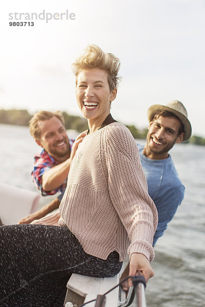 Porträt einer glücklichen Frau  die mit Freunden auf der Yacht genießt.