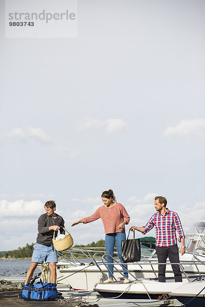 Freunde an Bord einer Yacht gegen den Himmel