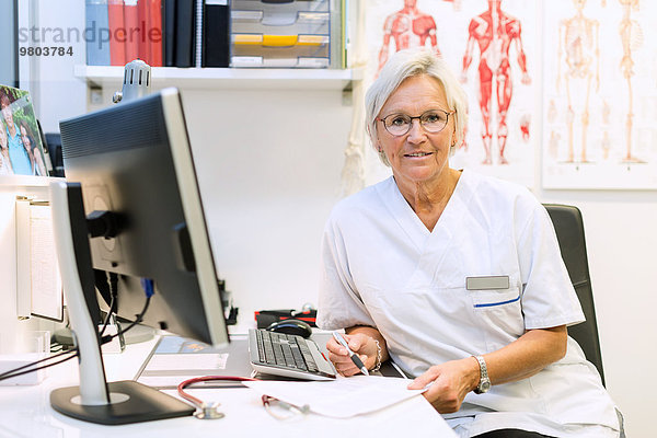 Portrait eines selbstbewussten orthopädischen Chirurgen am Computertisch in der Klinik
