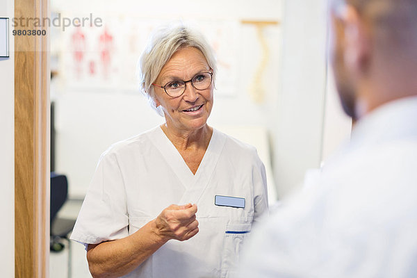 Oberarzt im Gespräch mit dem Mann in der orthopädischen Klinik