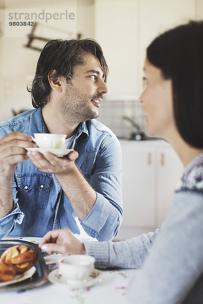 Mittlerer Erwachsener Mann beim Kaffee mit Frau am Frühstückstisch