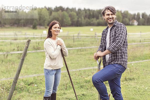 Ein glückliches  erwachsenes Paar  das auf einem Bio-Bauernhof arbeitet.