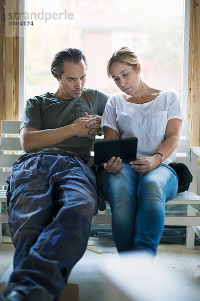 Paar mit Tablet-Computer im Haus in der Renovierung