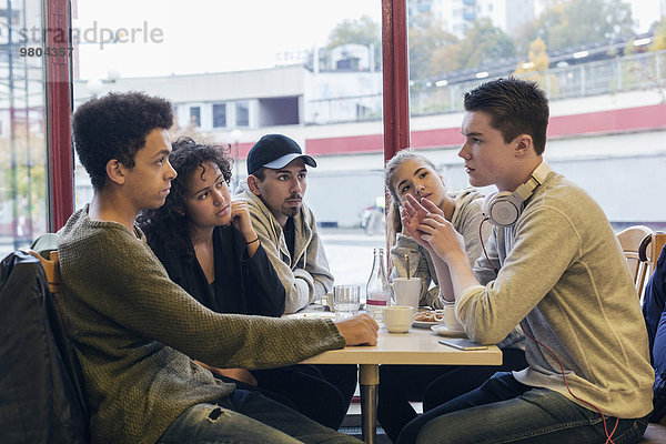 Studenten kommunizieren am Tisch in der Cafeteria