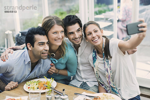 Lächelnde Geschäftsleute  die Selfie im Cafe nehmen