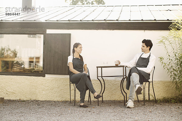 Kellnerin und Kellnerin bei der Kaffeepause vor dem Restaurant