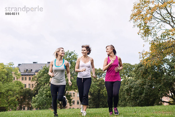 Volle Länge der Frauen beim Joggen im Park gegen den Himmel