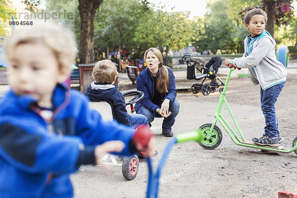 Wütende Lehrerin mit spielenden Kindern auf dem Spielplatz