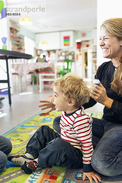 Fröhliche Lehrerin mit Blick in den Kindergarten