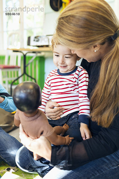 Lehrer zeigt Puppe dem Jungen im Kindergarten