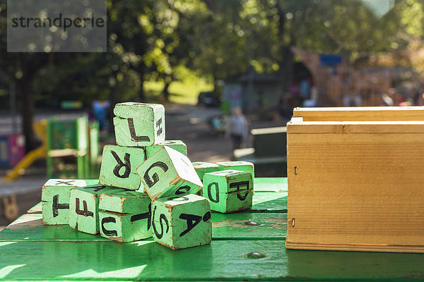 Grüne Holzklötze auf dem Tisch vor dem Kindergarten