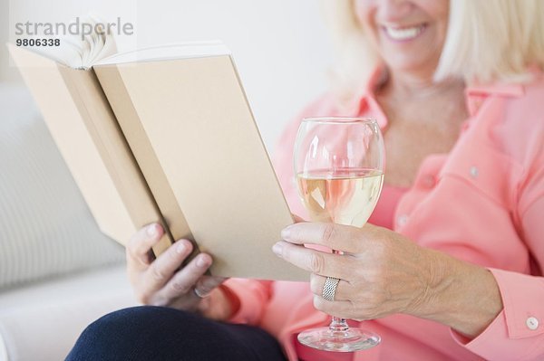 Senior Senioren Frau Buch Wein trinken Taschenbuch vorlesen