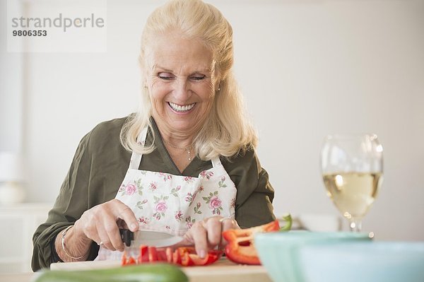 Senior Senioren Frau schneiden Peperoni