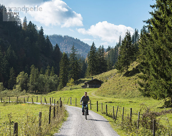 Junger Mann fährt Fahrrad  Berglandschaft  Valepptal  Spitzingsee  Bayern  Deutschland  Europa