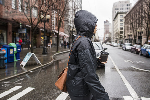 Junge Frau auf regnerischem Fußgängerüberweg  Seattle  Washington State  USA