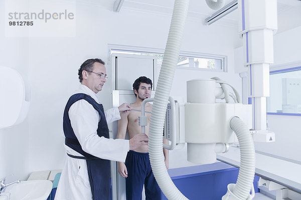 Röntgentechniker bei der Vorbereitung des Röntgengerätes im Stehen