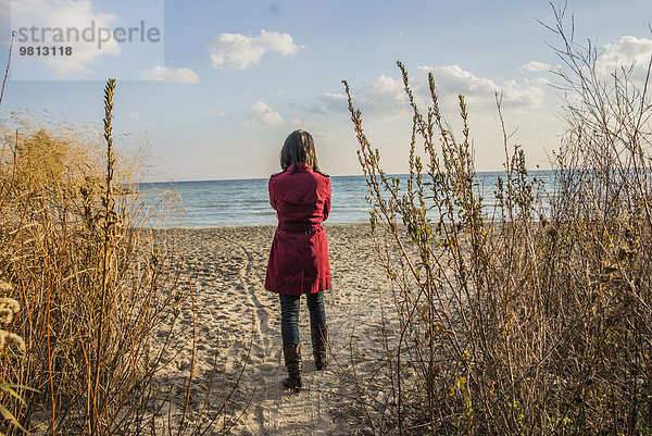 Mittlere erwachsene Frau am Strand stehend