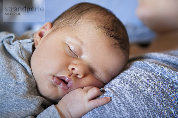 Baby Mädchen schläft auf der Brust der Mutter