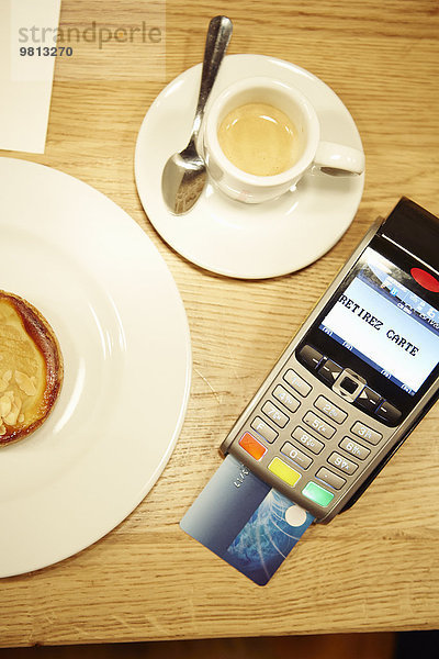 Teller  Kaffeetasse und Kreditkartenleser auf dem Tisch im Restaurant  Draufsicht