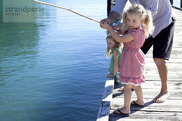 Erwachsener Mann und Tochter beim Fischen vom Pier  Neuseeland