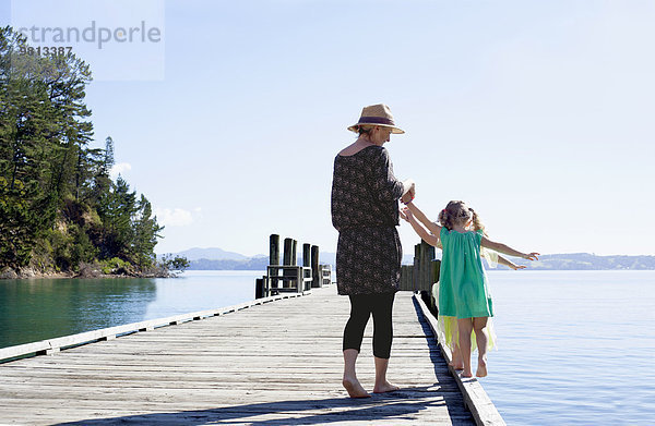 Mittlere erwachsene Frau und Töchter am Pier  Neuseeland