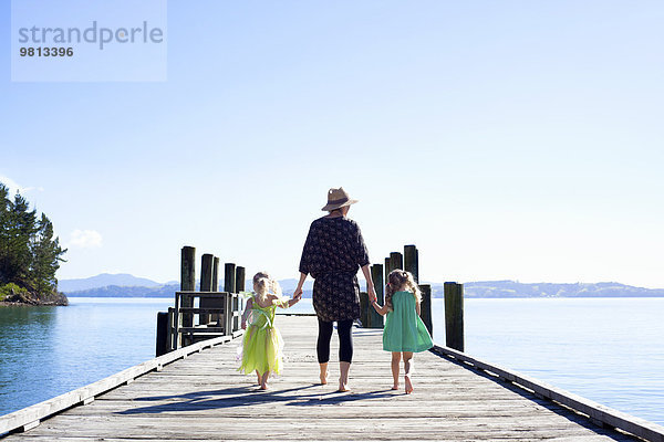 Mittlere erwachsene Frau und Töchter beim Spaziergang am Pier  Neuseeland