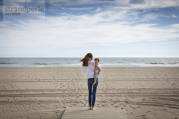 Rückansicht der mittleren erwachsenen Frau mit Kleinkind-Tochter am Strand  Castelldefels  Katalonien  Spanien