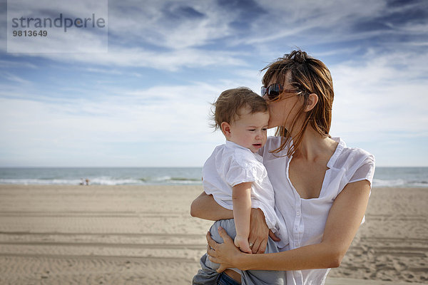 Mittlere erwachsene Frau küssend Kleinkind Tochter am Strand  Castelldefels  Katalonien  Spanien