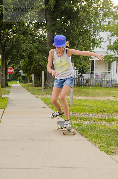 Mädchen auf dem Skateboard auf dem Weg
