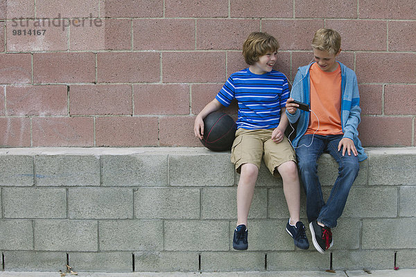 Zwei Jungen sitzen auf der Wand