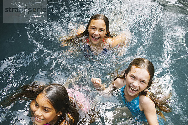 Drei Mädchen schwimmen im Schwimmbad