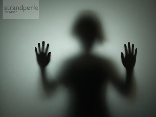 Silhouette der Person hinter Glas