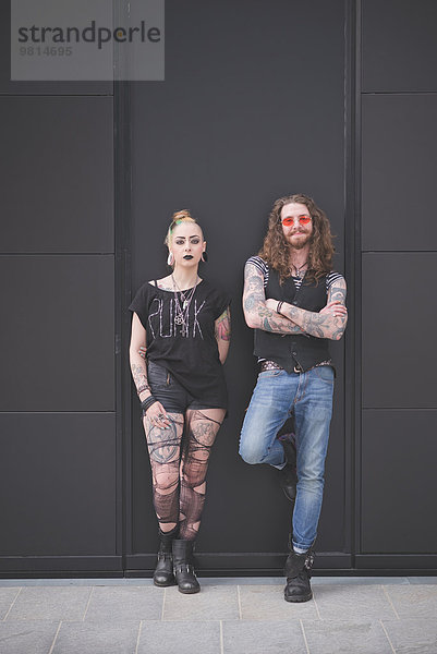 Porträt eines an die Wand gelehnten Punk-Hippy-Paares