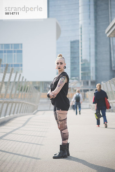 Portrait einer jungen tätowierten Punkerin auf der Straße