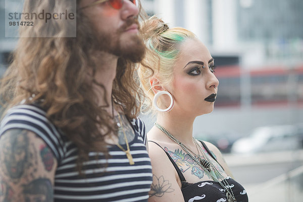 Porträt eines Punk-Hippie-Paares nebeneinander auf der City Street