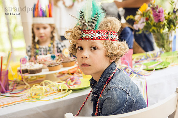 Porträt eines ernsthaft aussehenden Jungen auf einer Kindergeburtstagsparty