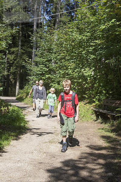 Eltern und Kinder wandern auf Waldweg  Berchtesgaden  Obersalzberg  Bayern  Deutschland