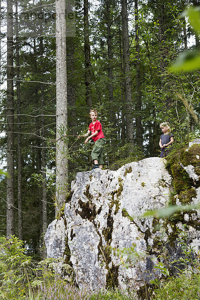 Geschwister spielen auf Felsformationen im Wald  Zauberwald  Bayern  Deutschland