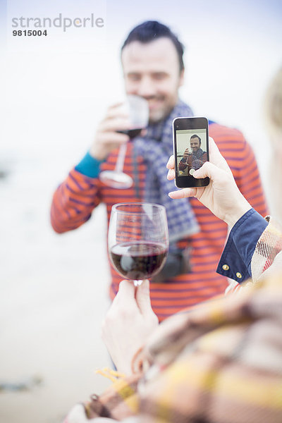 Paar im Freien  Wein trinken  Frau fotografiert Mann