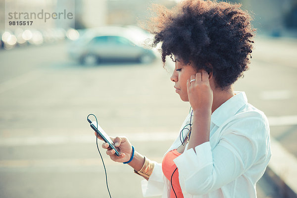 Junge Frau hört Smartphone-Musik