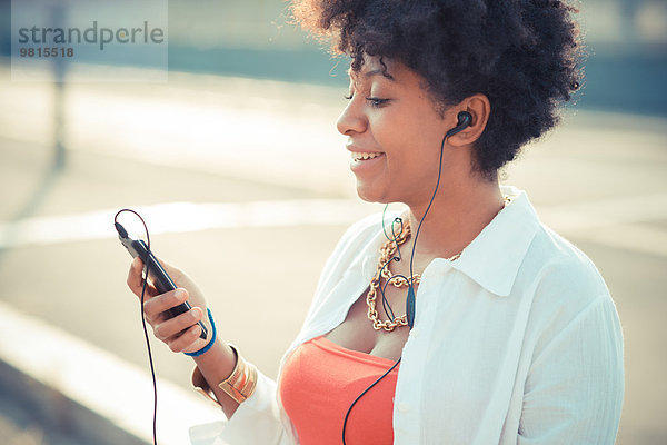 Junge Frau hört Smartphone-Musik